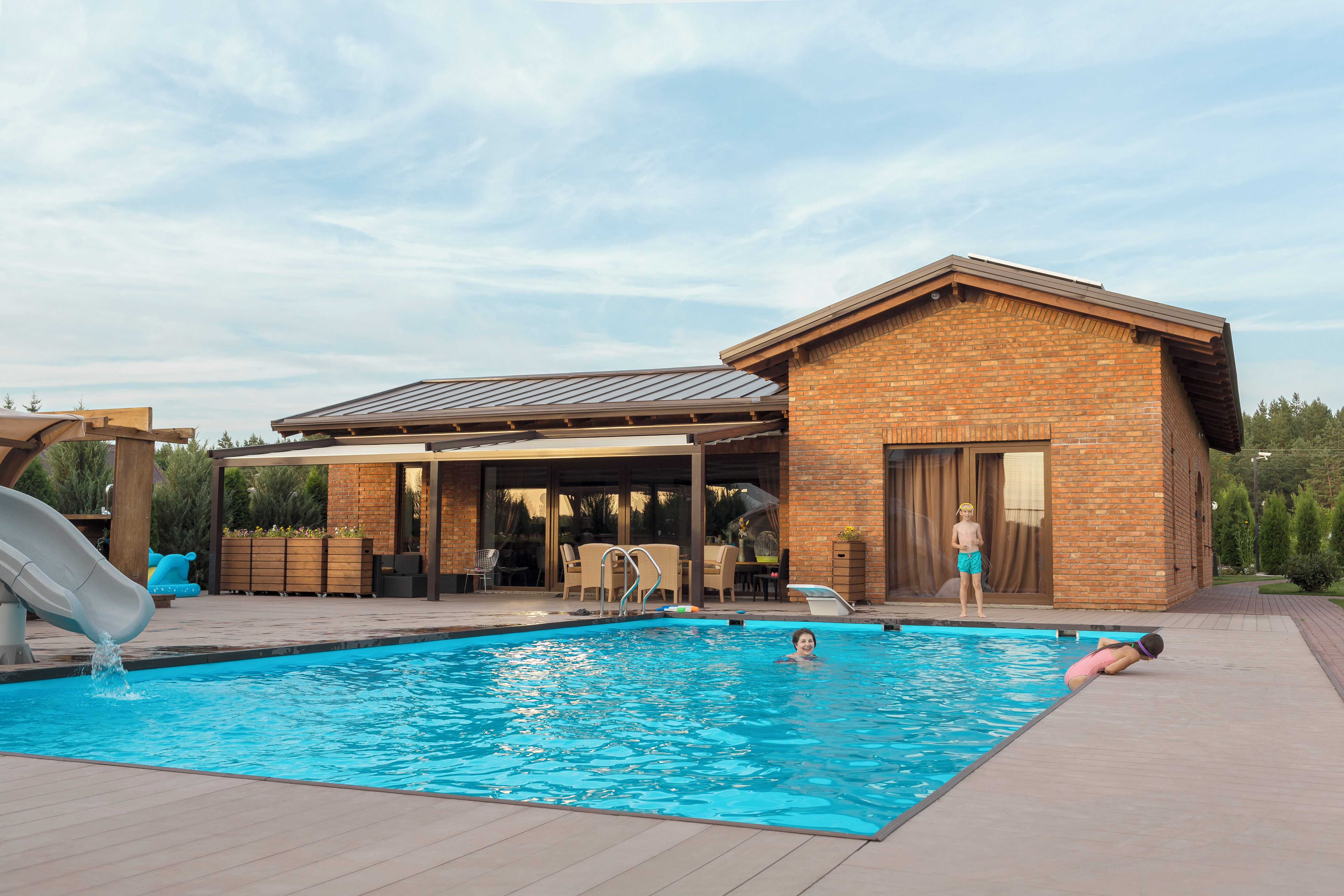 Residential swimming pool with a slide and children playing